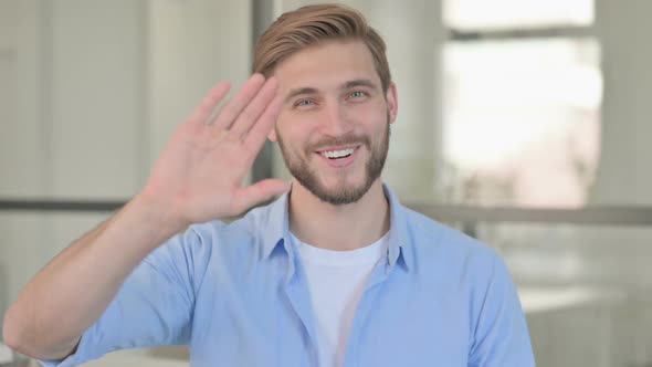 Portrait of Young Creative Man Waving Welcoming