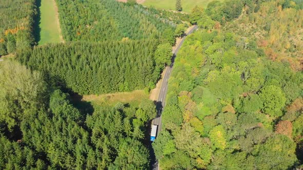 flying over a highway cutting through a forest