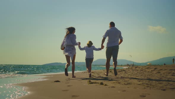 Parents with son running on sandy beach