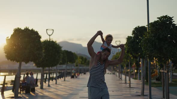 Father and Son Walking in City at Sunset