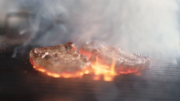 Steak Cooked on Grid Burning Fire Flame Surrounded By Steam at Grill