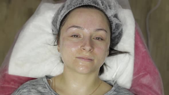 Portrait of Woman in Beauty Clinic Salon. Girl with Moisturizing Mask on Face