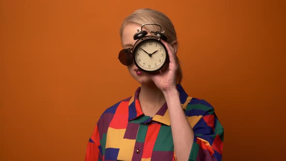 Style blonde in 90s shirt with alarm clock