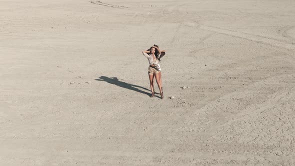 AERIAL Shot Two Young Women Is Standing in the Middle of the Desert They Rising Up Their Hands and