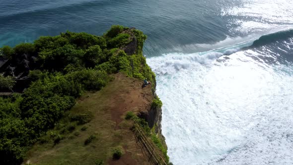 Man Sits on the Clifftop Above Ocean