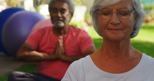 Senior friends performing yoga in garden 4k