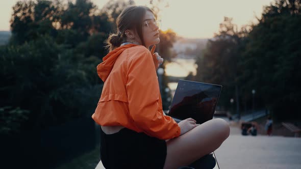 A Thoughtful and Tired Young Woman Arranges Her Glasses and Puts Her Head in Her Palm