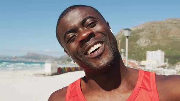 Portrait of smiling african american man, waving to camera, taking break in exercise outdoors