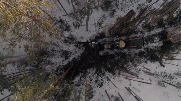 Top down Aerial view of harvester logging a trees in the winter forest 25