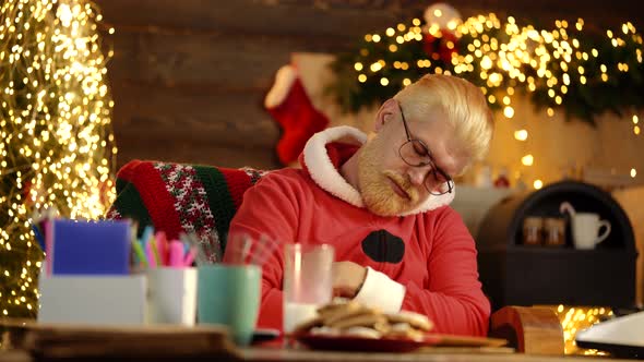 Santa Claus Boring. Tired Santa Claus Sleeping on the Table at Home