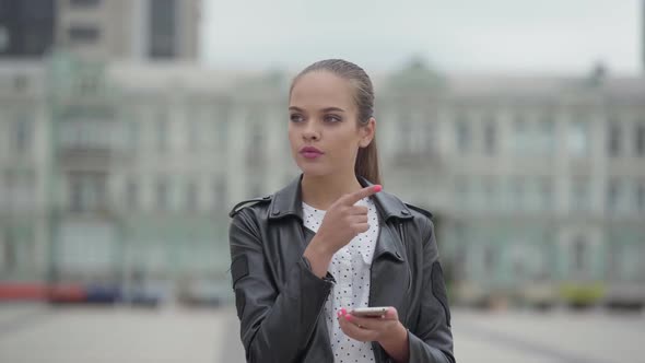 Portrait of Beautiful Happy Girl Standing in the Early Morning on the Background of Empty City