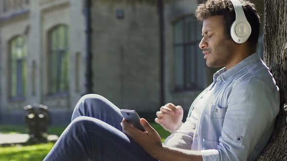 Biracial Guy Listening to Favorite Radio Station Enjoying Sound in Headphones