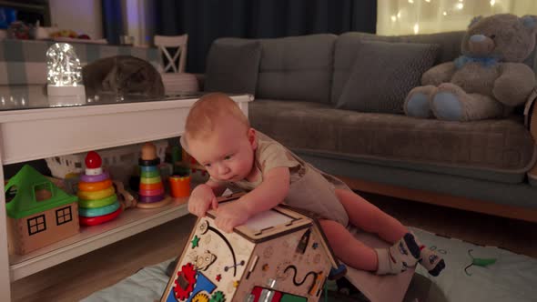 Adorable Baby Sitting in Infant Bouncer 10 Month Old Caucasian Kid Playing with Wooden Busy House