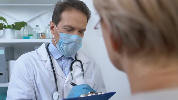 Male Therapist Writing Woman Patient Data in Medical Records, Health Check-Up