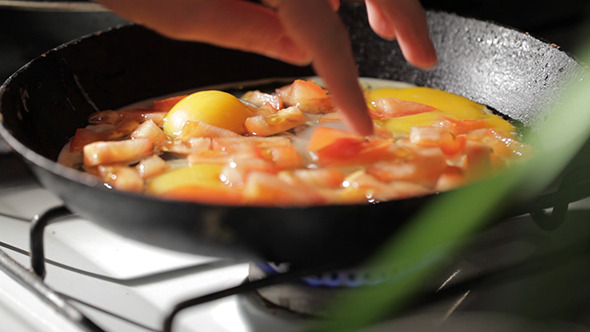 Egg Frying In A Pan Adding Tomato Slices