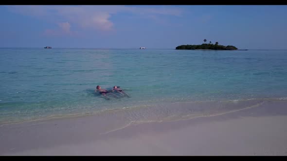 Two people in love on tropical island beach break by blue sea with white sand background of the Mald