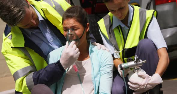 Patient receiving oxygen mask from ambulance team