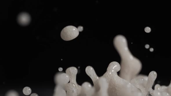 White Droplets Of Paint Flying Up Into Air