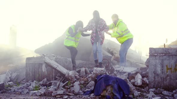 Portrait Rescuers in Uniform Help the Victim of the Earthquake ,Pulling Her Out From Under the Ruins