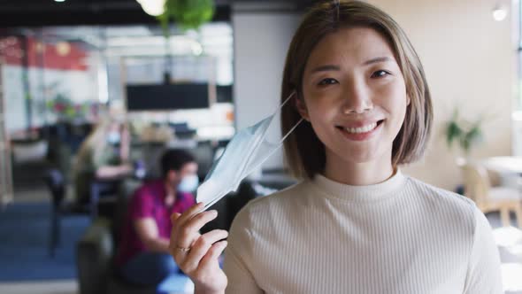 Portrait of asian businesswoman looking at camera smiling in modern office