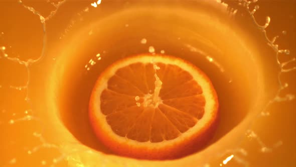 Super Slow Motion Round a Piece of Orange Falls Into the Orange Juice