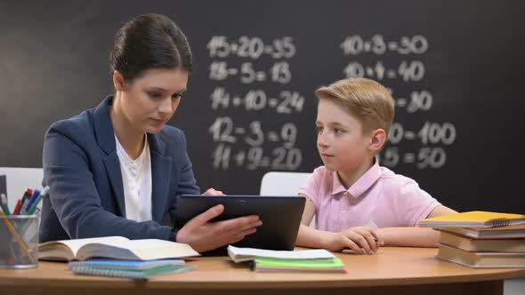 Young Teacher Showing Schoolboy Information on Tab, Private Lesson, Innovations