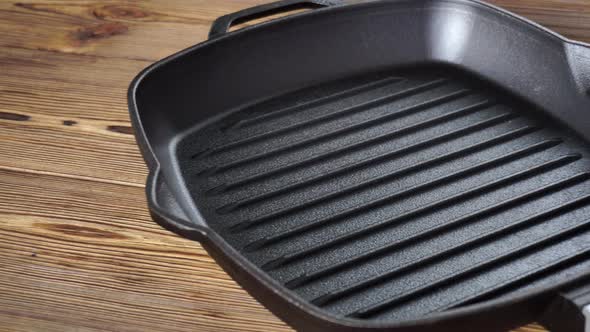 Cast Iron Grill Pan with Removable Wooden Handle on Wooden Background
