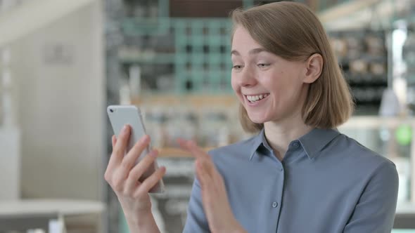 Portrait of Young Woman Celebrating Success on Smartphone