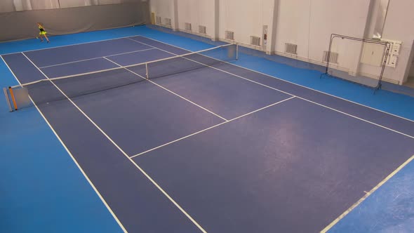 Extreme Wide Shot of Tennis Court in Gym with Two Professional Slim Caucasian Women Hitting Ball