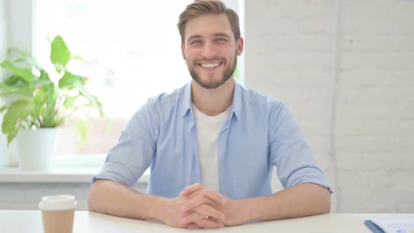 Young Creative Man Smiling at Camera in Modern Office