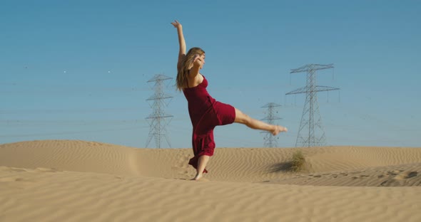 Sexy Woman Wearing Red Dress is Dancing on the Sand of Great Sandy Desert