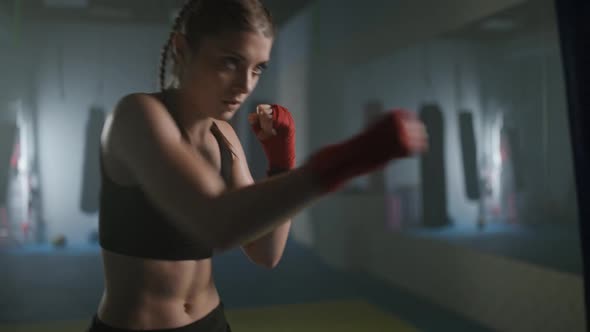 Female Fighter Beats a Punching Bag and Trains His Punches Training Day in the Boxing Gym the Female