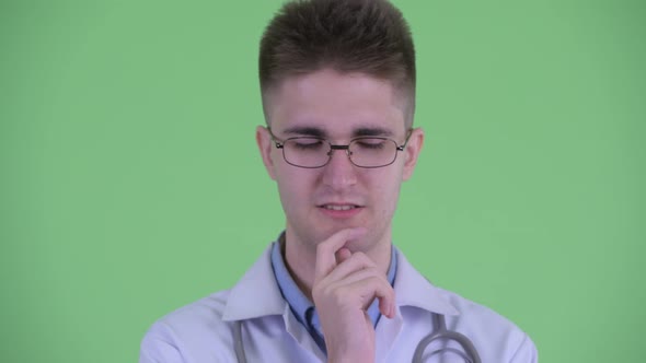 Face of Stressed Young Man Doctor Thinking and Looking Down