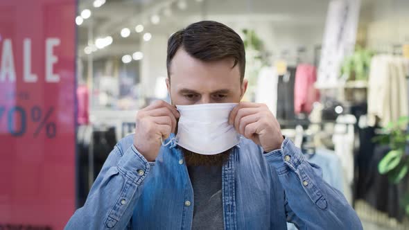 Front view of man putting a protective face mask. Shot with RED helium camera in 8K.