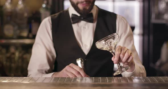 The Bartender Is Filling a Glass with Ice. 