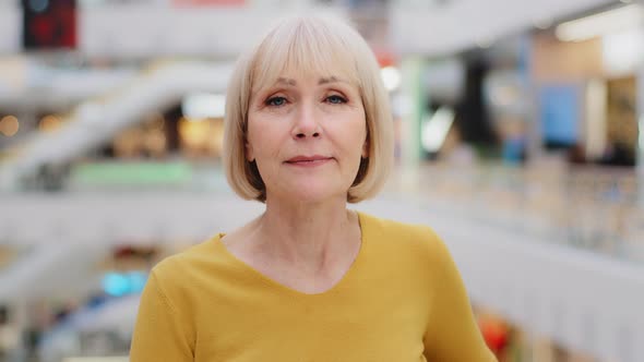 Closeup Elegant Mature Caucasian Woman Looking at Camera Smiling Posing Indoors Waving Head Nodding