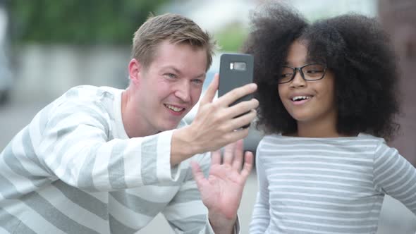 Young Cute African Girl with Afro Hair and Young Scandinavian Man Together in the Streets Outdoors