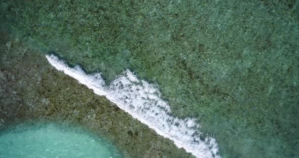 Natural birds eye travel shot of a sandy white paradise beach and aqua blue water background in best