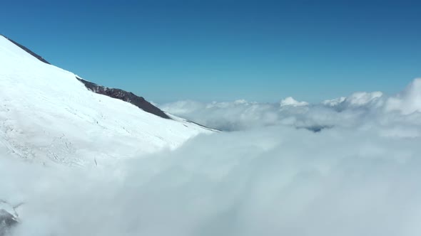 Ancient Elbrus Mountain with Heavy Ice and Snow in Clouds