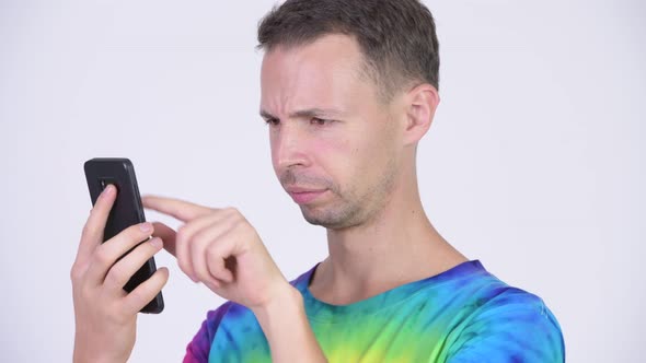 Studio Shot of Happy Man with Tie-dye Shirt Using Phone