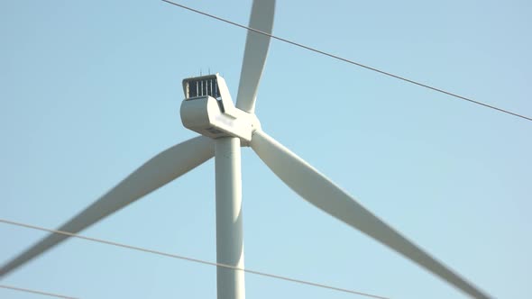 Close Up of Wind Turbine Spinning on Blue Sky Background