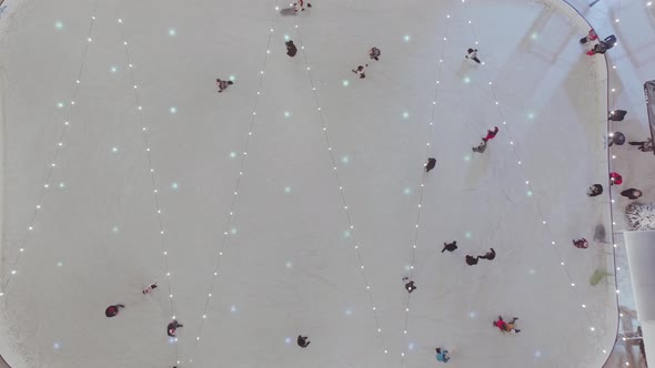 Aerial descending over flashing lights and people skating on ice rink in Zakopane. Poland