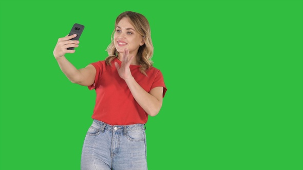 Cute girl making selfie walking on a Green Screen, Chroma Key.