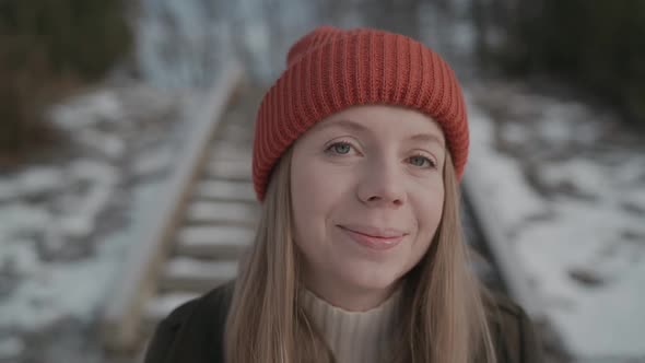 Girl in an Orange Hat in Winter Looks Around and Smiles, Happy Woman