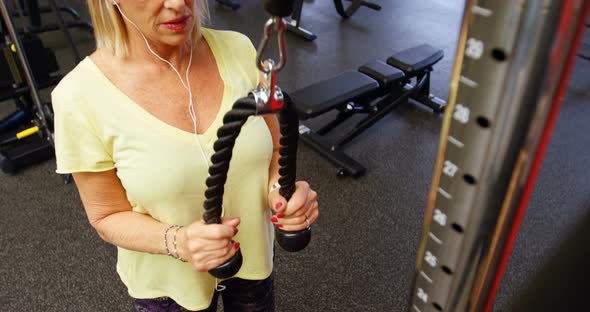 Senior woman doing triceps exercise in fitness studio 4k