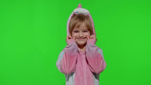 Child Girl in Unicorn Pajamas Making Silly Funny Faces Fooling Around Showing Tongue on Chroma Key