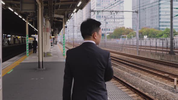 Japanese businessman waiting on a train platform