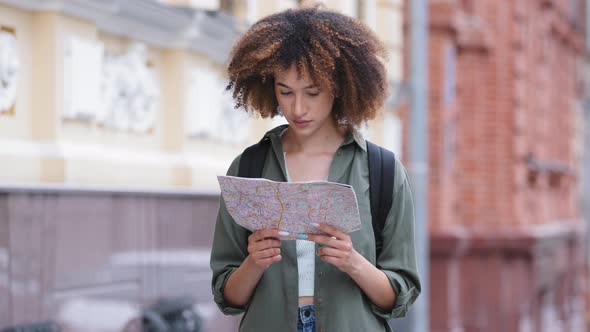 Attractive Young African American Woman Traveling and Exploring Beautiful Sightseeing Holding Map of