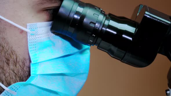 A young scientist conducting research with a microscope. Working with a microscope.