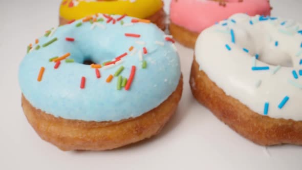 Delicious Multi-colored Donuts on a White Background. Smooth Dolly Motion